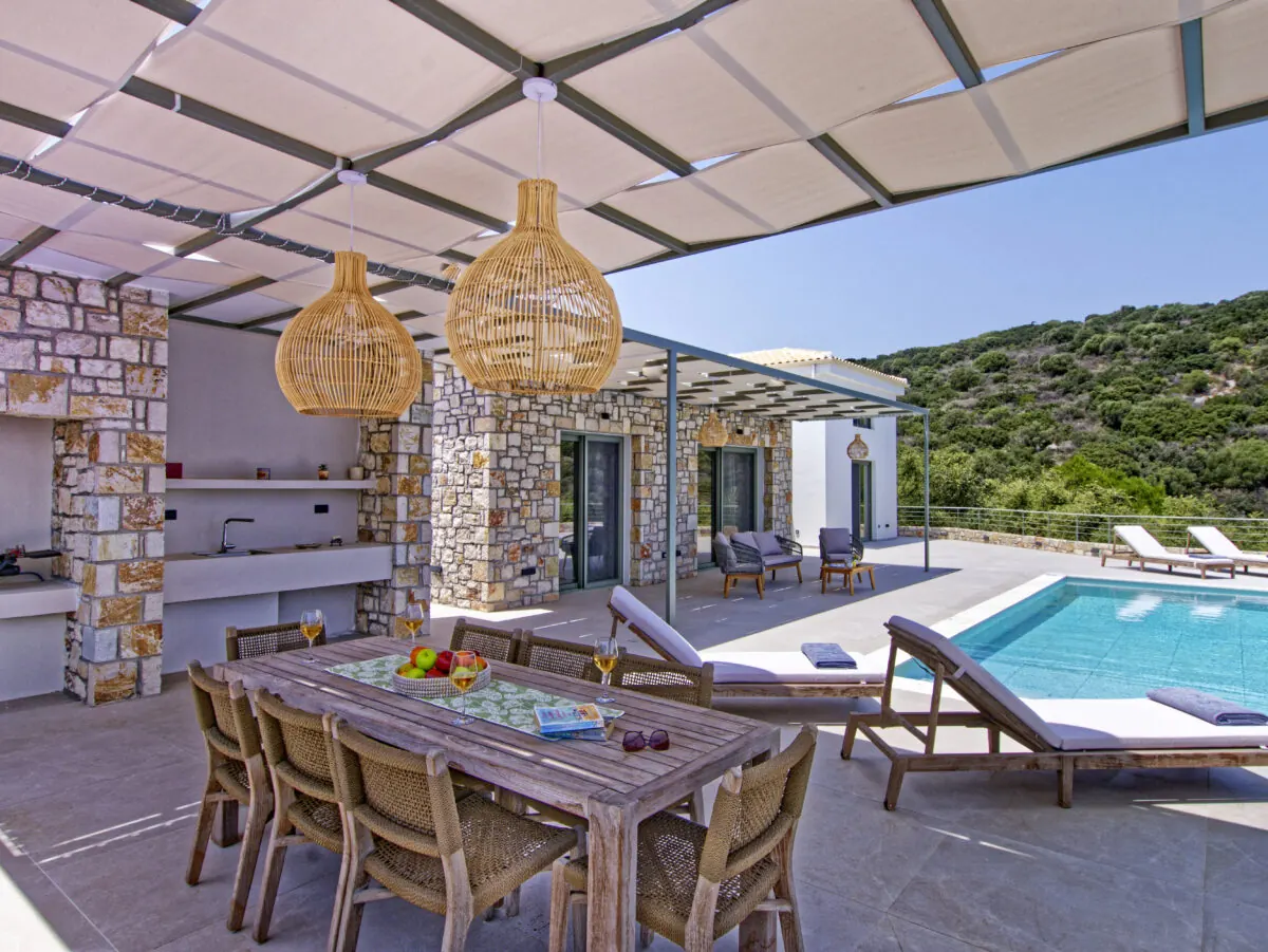 Shaded pergola dining terrace beside the pool at Alios