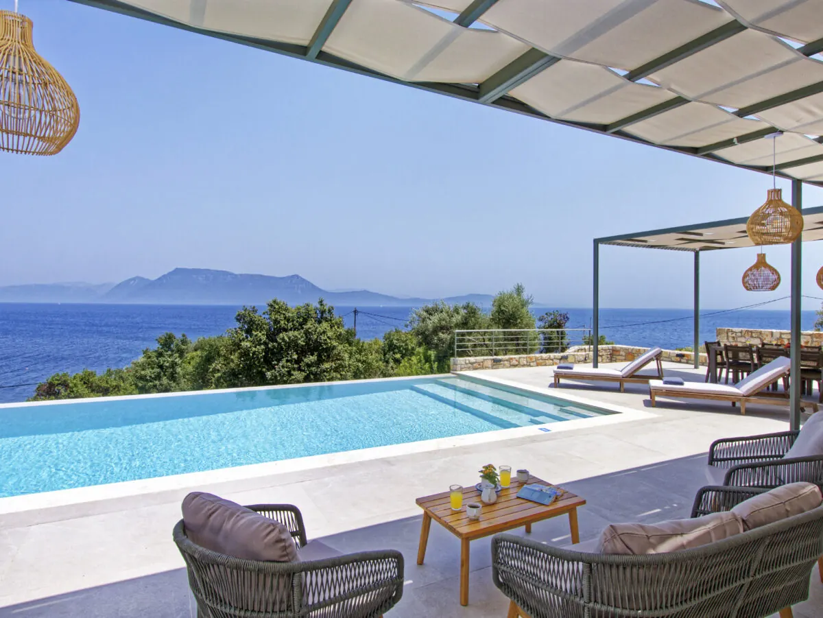 Shaded pergola dining terrace beside the pool at Alios