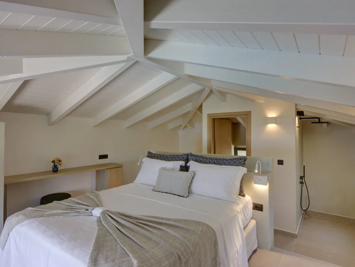 Upper-level bedroom beneath the beams at Astir