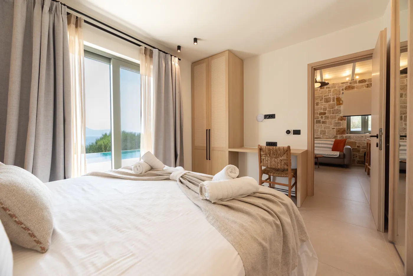 Quiet bedroom with natural stone and timber at Apílion