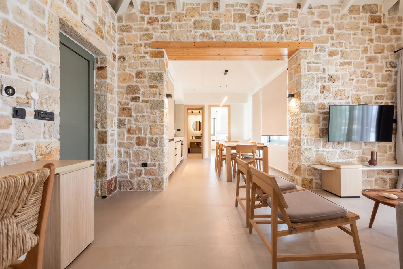 Open-plan stone living room and kitchen at Apílion